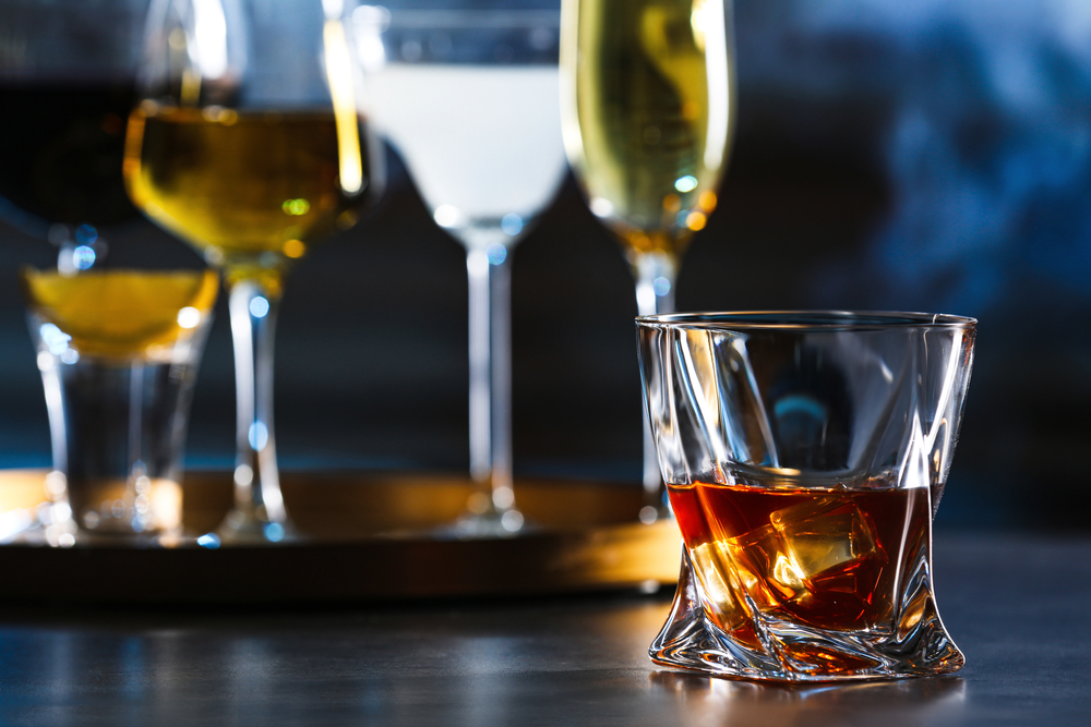 Glass of alcoholic drink on table, closeup. Space for text

