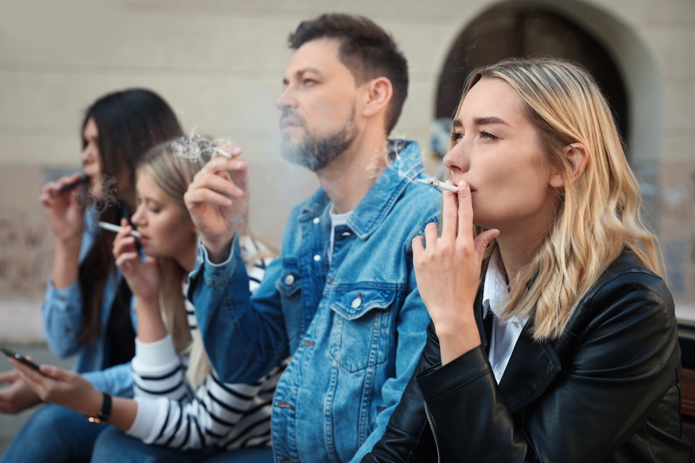 People smoking cigarettes at public place outdoors