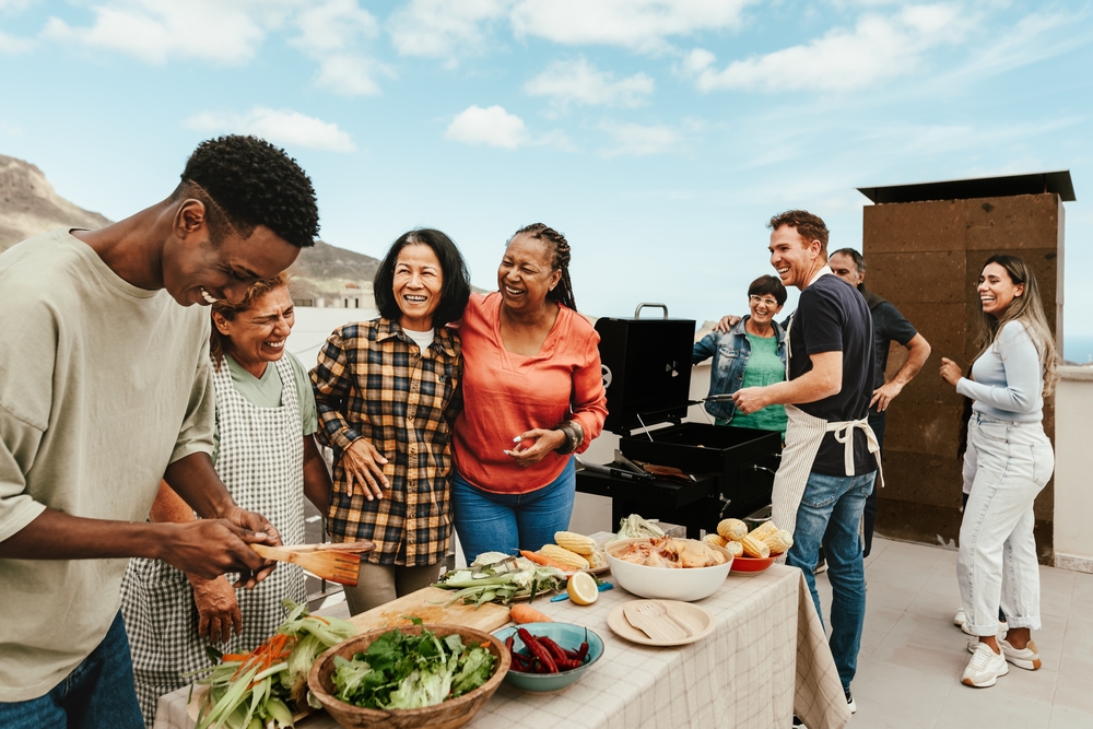 Happy multigenerational people having fun doing barbecue grill at house rooftop - Summer gatherings and food concept

