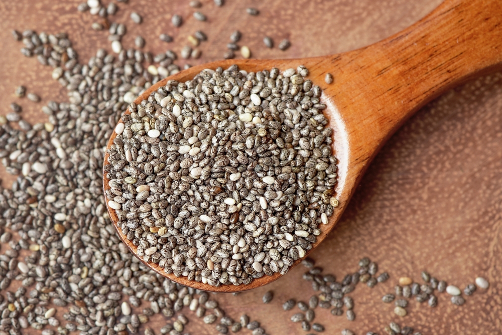 Close up of chia seeds in a wooden spoon. Chia seeds contain fibre and omega-3 fatty acids, protein, many essential minerals and antioxidants. Healthy eating concept.
