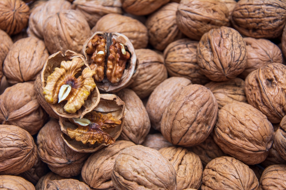 Cracked walnuts on a background covered with walnuts