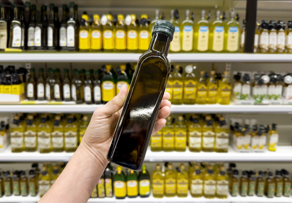 choosing olive oil, sauce, vinegar at the grocery store
