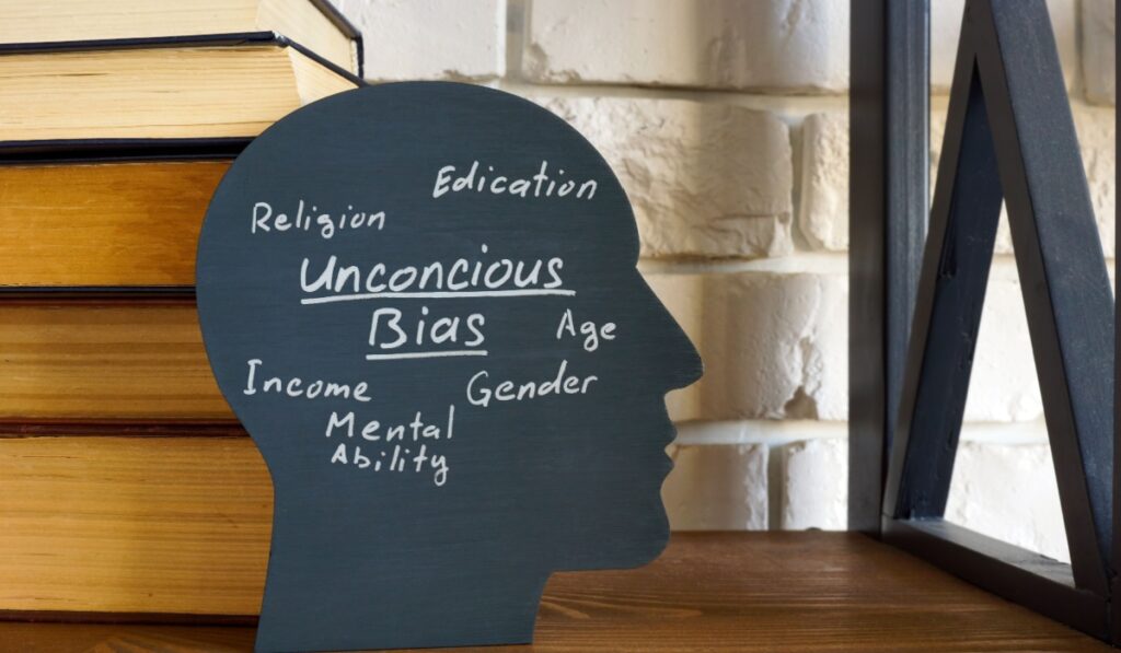 A stack of books and a head with an inscription unconscious bias.
