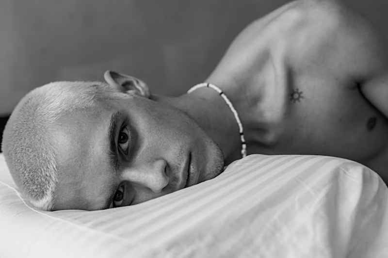 man with eyes open laid on pillow
