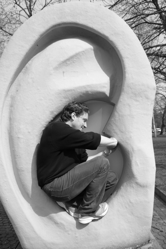 black and white photo of man sitting inside an ear