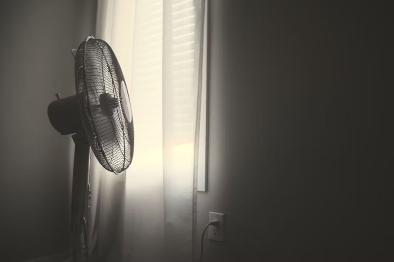 a fan pointed at a bedroom window