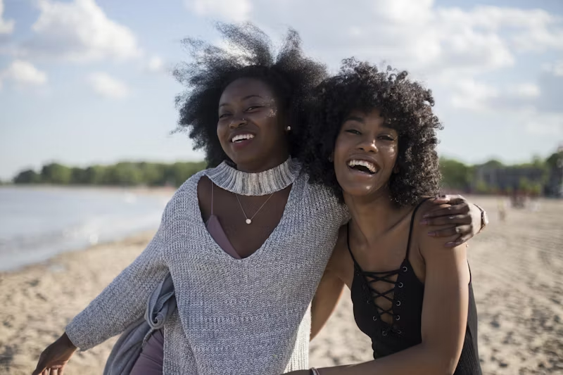 two women of colour on a beach