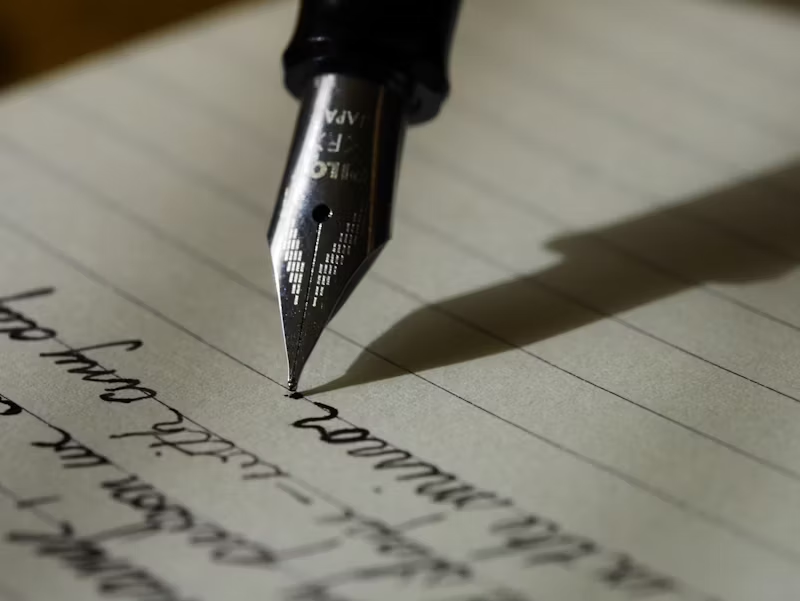 a pen writing on paper