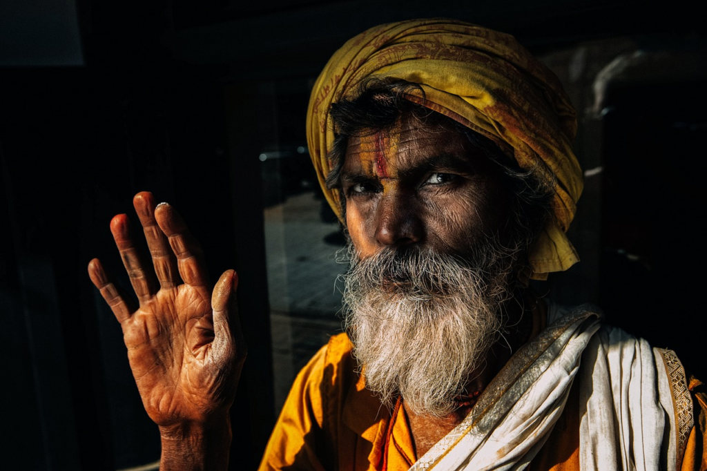 older man with mouth closed waving