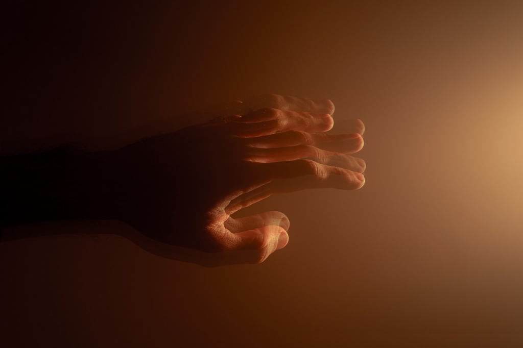a blurry, shaky hand reaching out