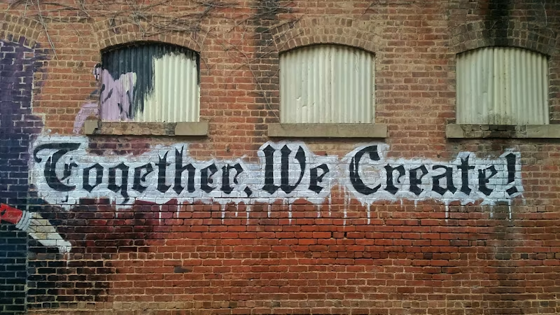 a wall with "Together, We Create" written on it