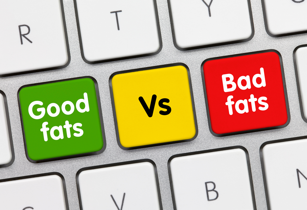 good fats vs bad fats Written on Green Key of Metallic Keyboard. Finger pressing key.
