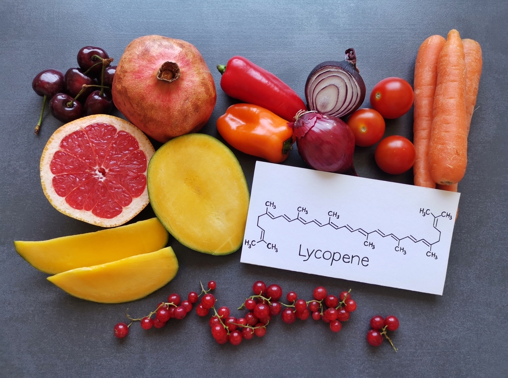 Foods rich in lycopene with structural chemical formula of lycopene molecule. Natural food sources of lycopene: tomato, grapefruit, pomegranate, red bell pepper, mango, red onion, cherries and carrot.
