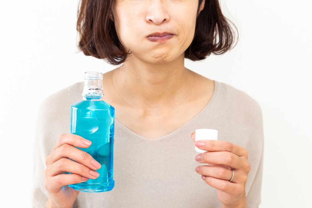 A Japanese woman uses mouthwash.
