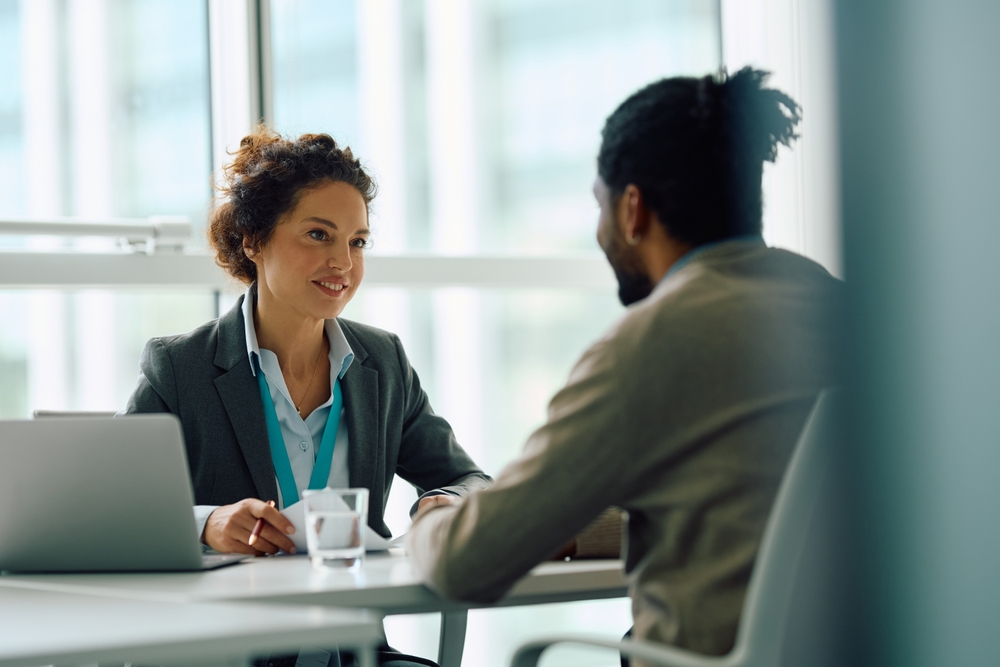 Human resource manager communicating with African American candidate during job interview in the office. Copy space.