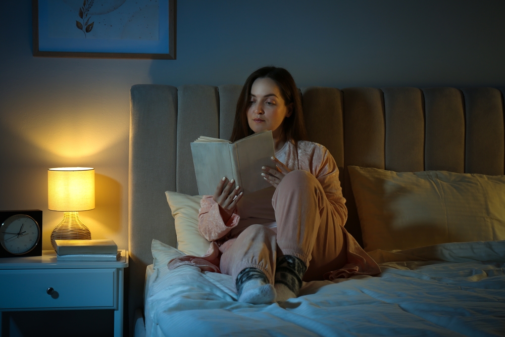 Beautiful woman reading before bed at night
