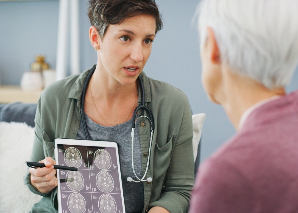 Woman, doctor and brain scan with tablet, xray and MRI results in hospital with surgery planning. Healthcare, senior and medical advice for dementia test with professional and wellness consultation