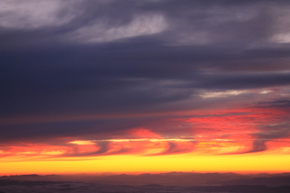 The sky above the landscape colored by the first rays of the sun (Kelvin-helmholtz clouds)