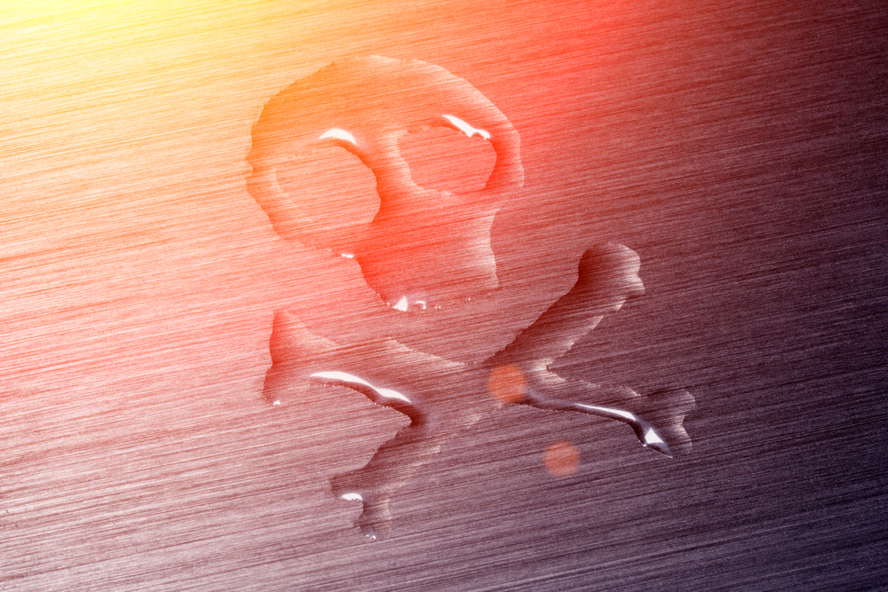 The skull on the bones, painted with water on the metal surface
