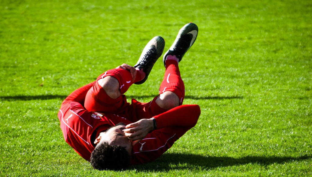 a soccer player holding onto their leg in pain