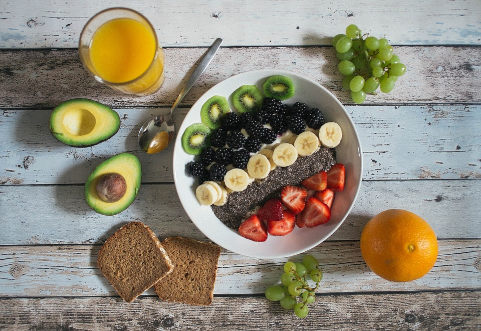A colorful plate filled with fresh fruit and vegetables arranged neatly on a wooden table.