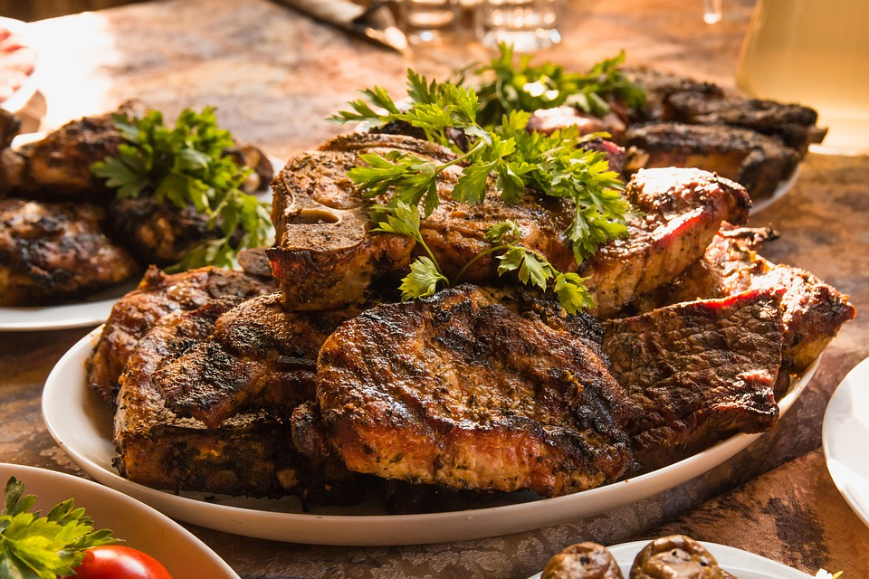 A richly set table showcasing multiple plates of assorted meats and vegetables, creating an appetizing and abundant spread.