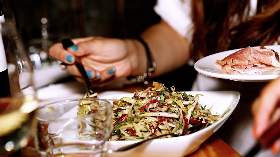 A woman practices mindful eating while holding a plate of nutritious food