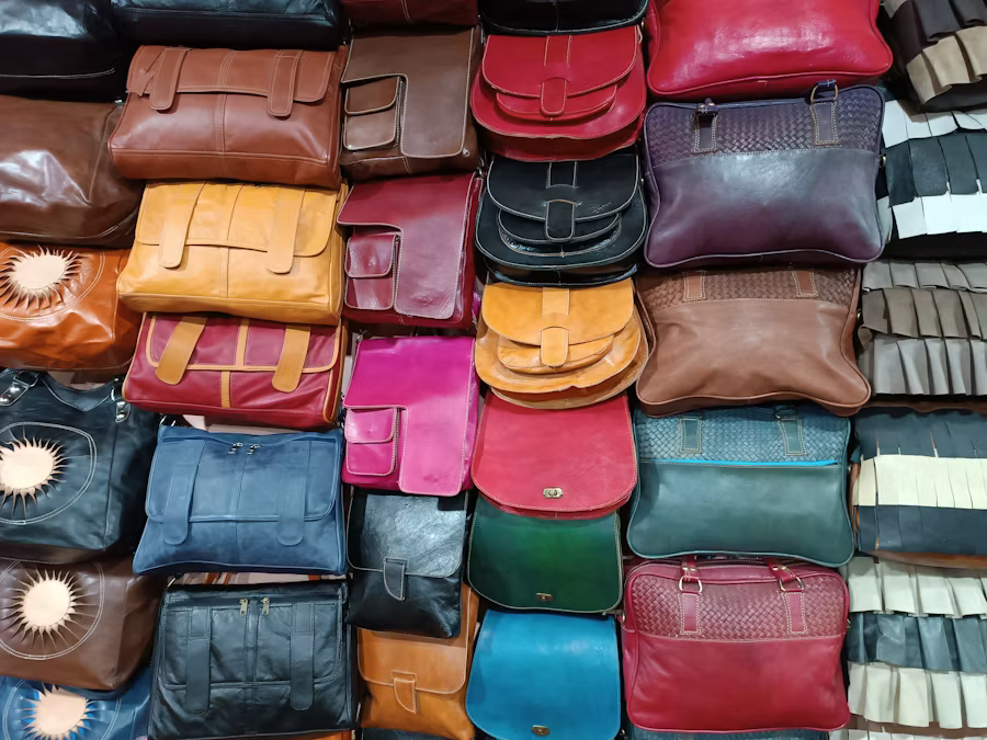A large assortment of leather bags stacked together, showcasing various colors and styles in a visually appealing arrangement.