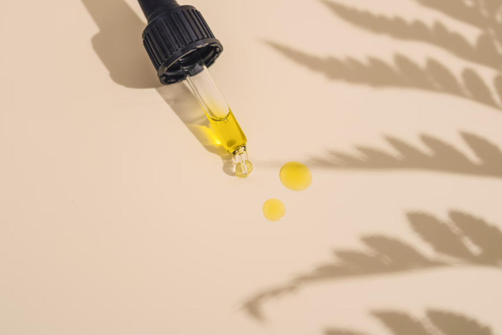A bottle of skincare oil is being poured into a table, showcasing its rich texture and luxurious appearance.