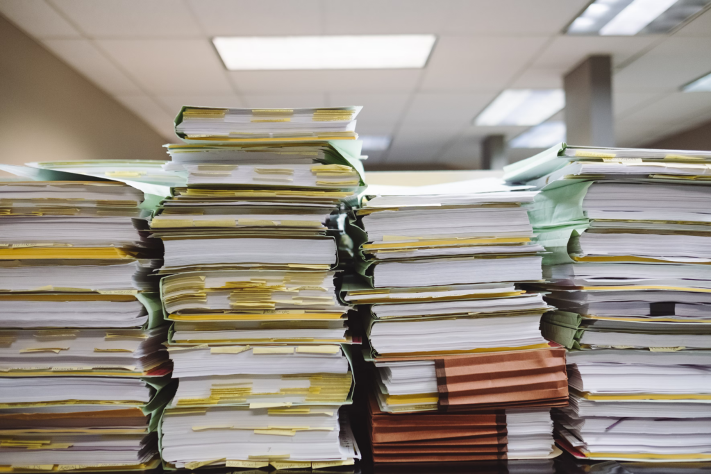 A decluttered stack of papers arranged on a wooden desk, showcasing a tidy workspace.