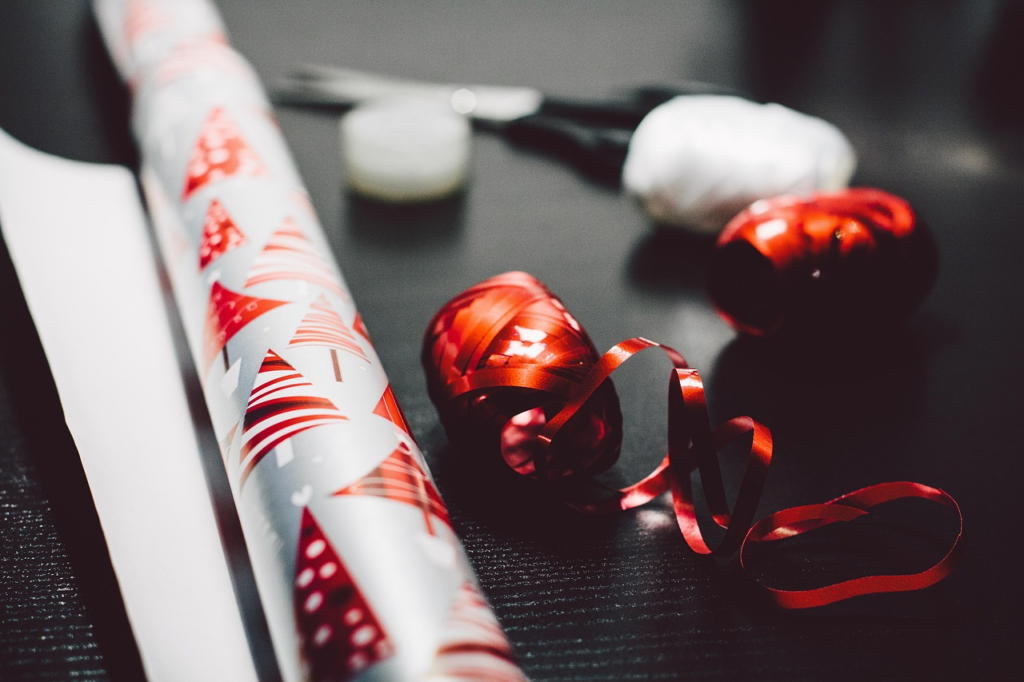 Christmas wrapping paper and scissors arranged neatly on a table, ready for gift wrapping and holiday preparations.