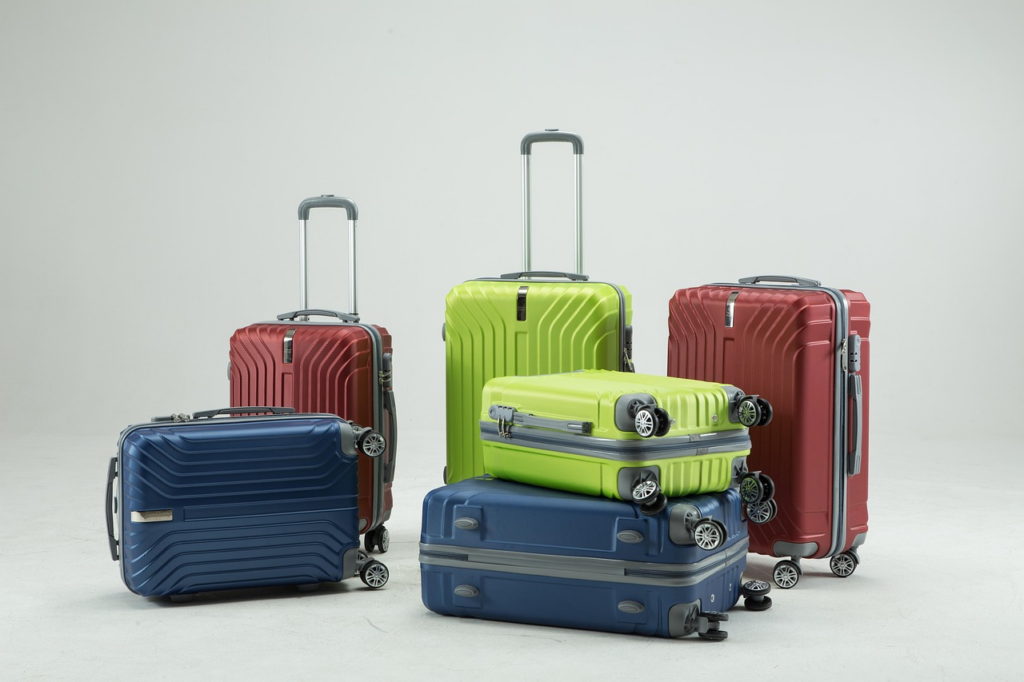 Four wheeled luggage pieces with handles arranged neatly, showcasing various colors and sizes for travel convenience.