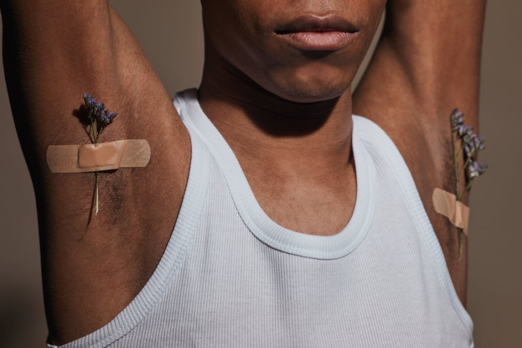A man displaying bandages on his arms, symbolizing his journey through injury and the process of healing.
