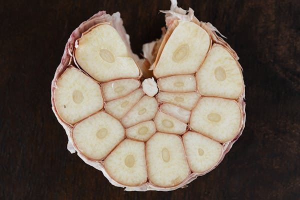 Full head of garlic cut in half, showing garlic cloves inside