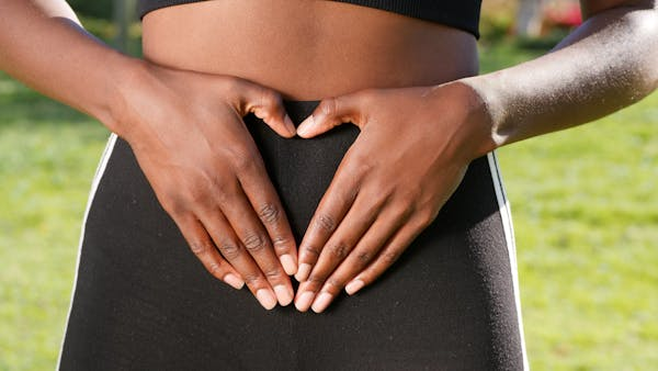 woman with hands places on stomach