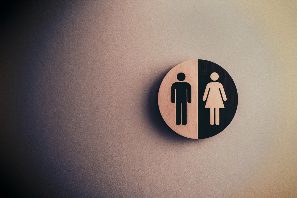 A restroom sign displaying male and female icons, symbolizing gender representation in discussions of midlife changes.