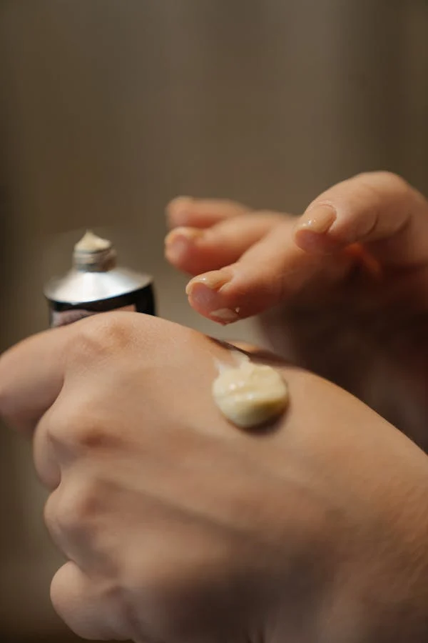close up of hands with moisturizer on them