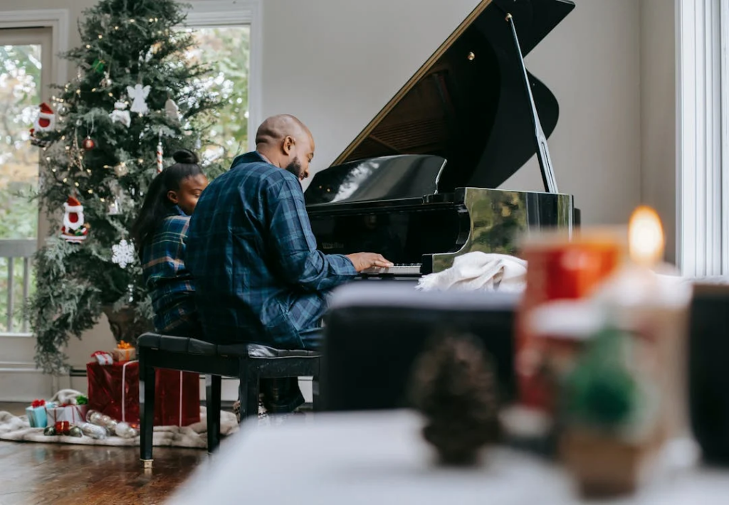 Black father playing piano with little daughter