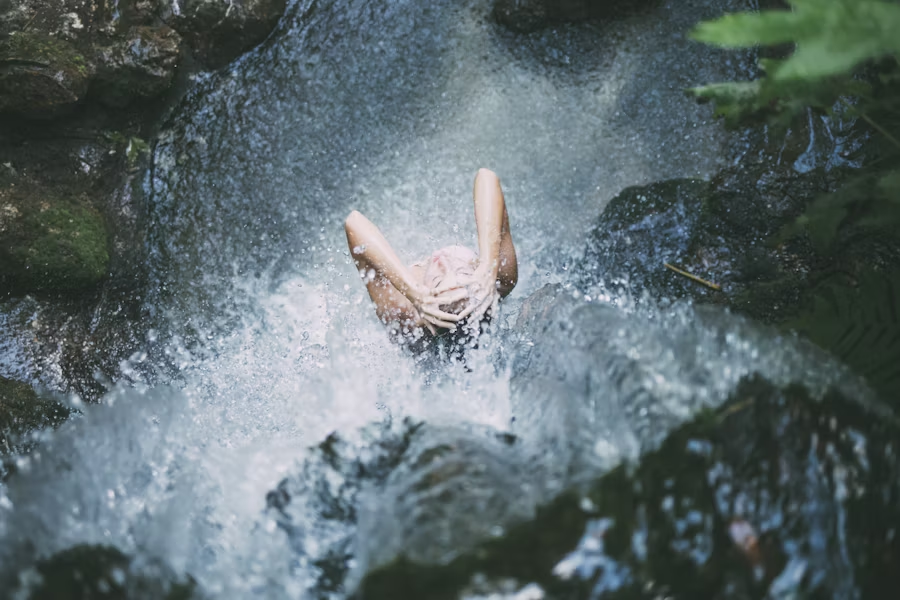 a woman showering under a waterfall