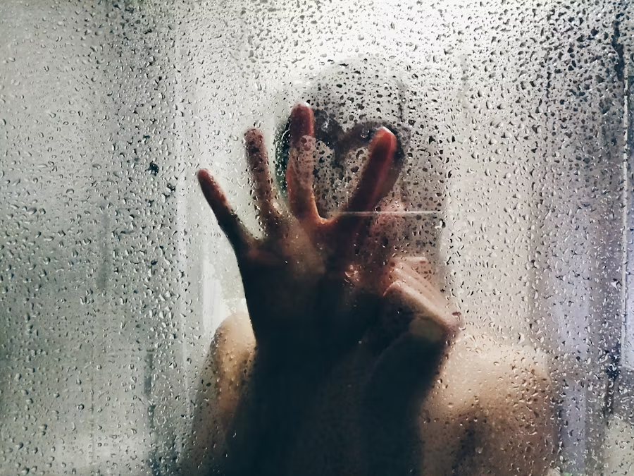 person in the shower writing a heart in the steamed wall
