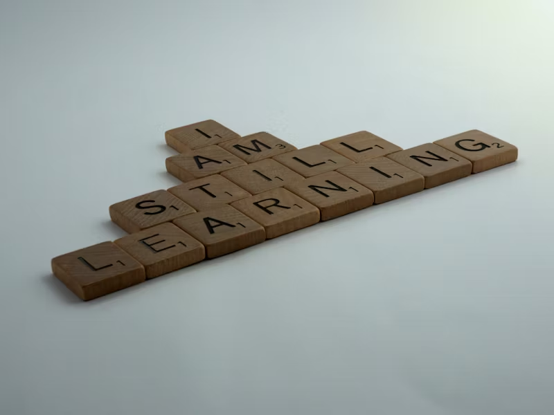 Scrabble letters reading "I AM STILL LEARNING"