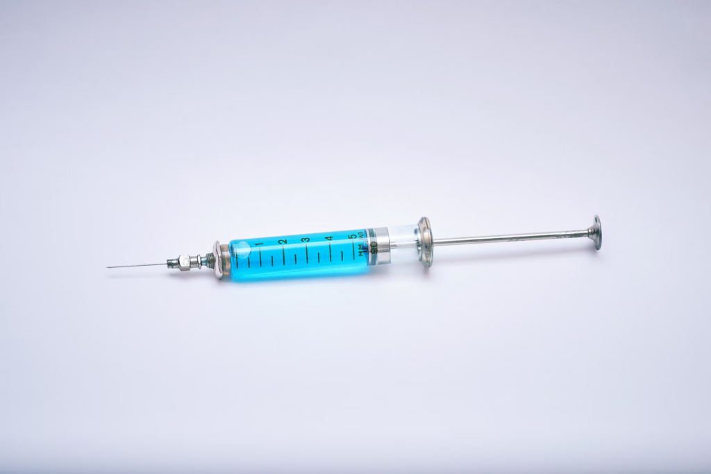 An injection syringe on a white background, representing Fertilo's minimal hormone approach in fertility treatments.