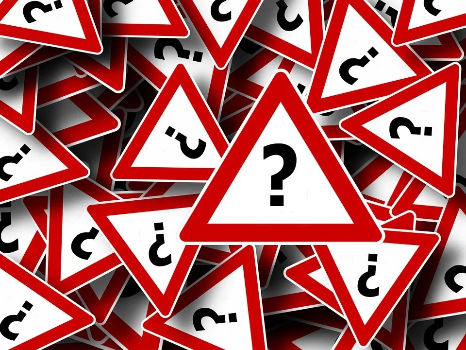 A stack of red and white traffic signs featuring question marks, symbolizing inquiries about walking benefits.