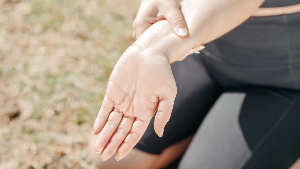 A woman reaches out with her hand, showing signs of wrist pain, emphasizing that walking can help alleviate discomfort.
