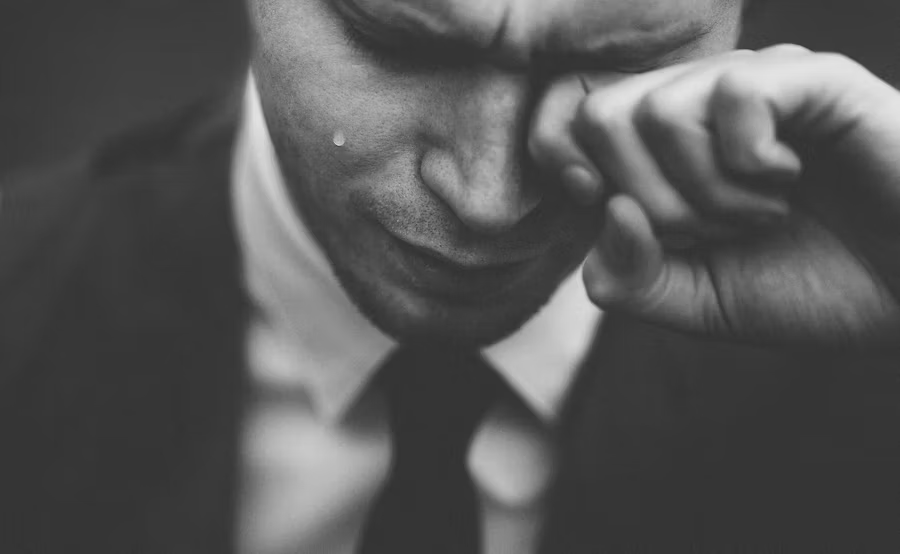 a man in a suit crying in black and white