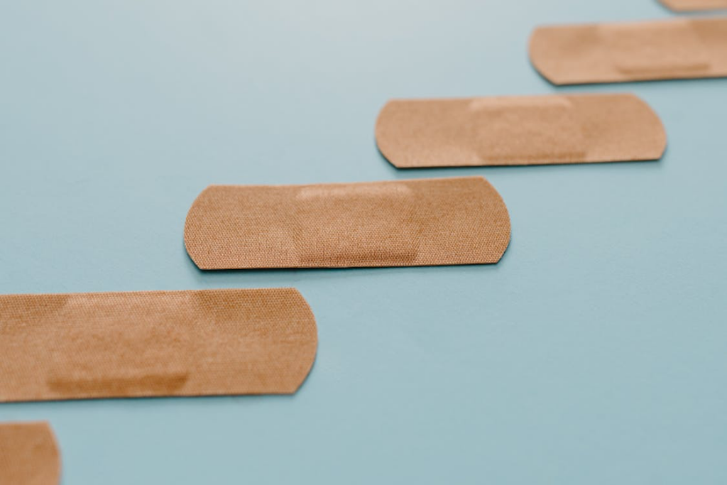 Plasters stuck on a blue background, symbolizing how wounds need oxygen and nutrients for effective healing.
