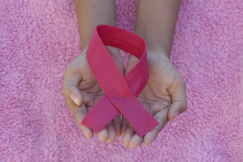 hands holding a breast cancer sash