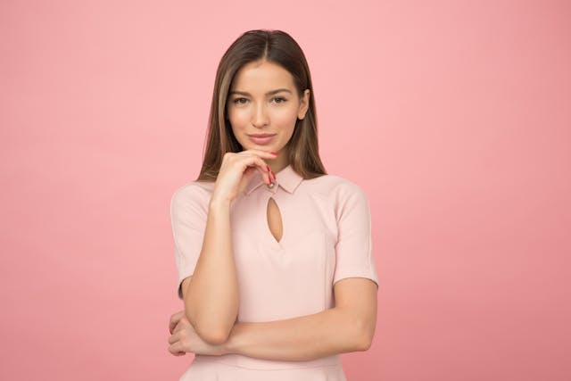 woman looking at camera, pink background
