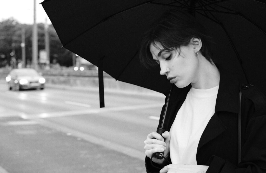 A woman with an umbrella standing on the street
