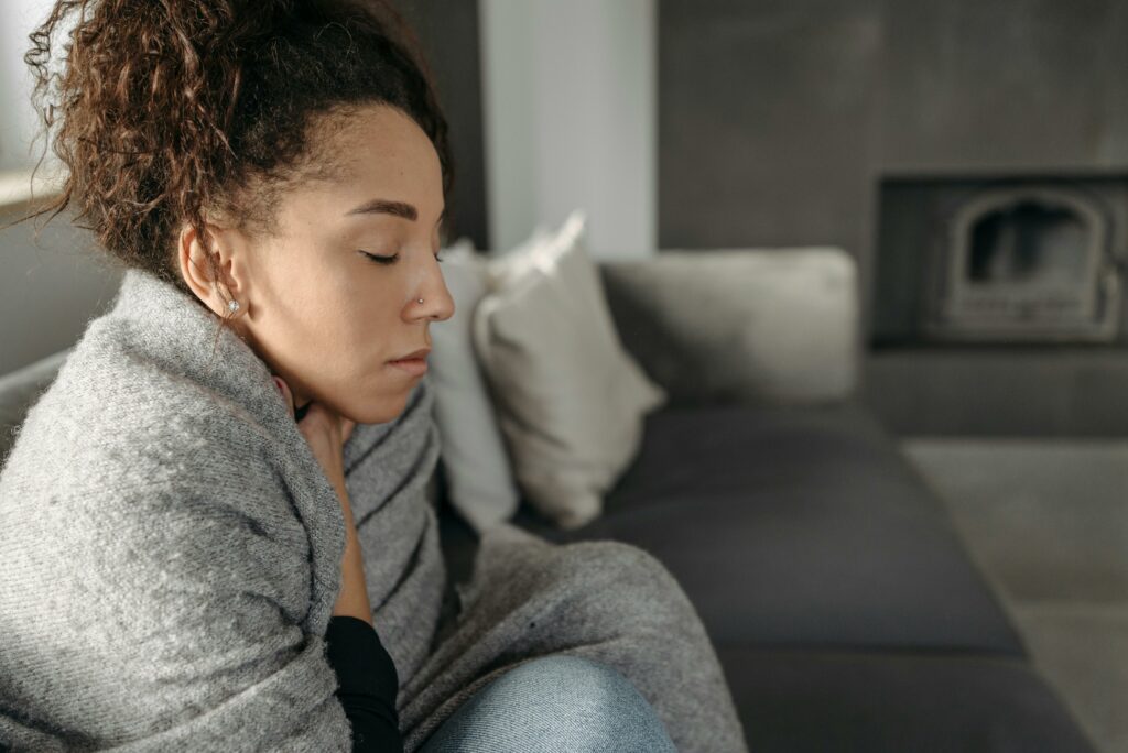 woman wrapped in a blanket sitting on a couch